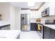 Bright kitchen with stainless steel appliances, white cabinets, and a skylight for ample natural light at 14300 W Bell Rd # 222, Surprise, AZ 85374