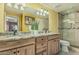 Well-lit bathroom with a double vanity, granite countertop, and a glass-enclosed shower at 145 N 74Th St # 240, Mesa, AZ 85207