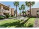 Complex common area with lush lawn, tall palm trees, picnic tables, and BBQ at 145 N 74Th St # 240, Mesa, AZ 85207