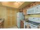 Kitchen featuring white appliances, granite counters, and light wood cabinets at 145 N 74Th St # 240, Mesa, AZ 85207