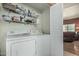 Functional laundry room featuring a washer, dryer, shelving, and ample storage space at 145 N 74Th St # 240, Mesa, AZ 85207