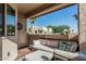 Relaxing covered patio with comfortable seating, textured walls, and a view of palm trees at 145 N 74Th St # 240, Mesa, AZ 85207
