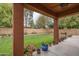 Cozy back patio with a textured ceiling, overlooking a green backyard and colorful flower pots at 15140 W Glenrosa Ave, Goodyear, AZ 85395