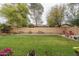 Expansive backyard with lush lawn, flower beds, and a brick fence for added privacy at 15140 W Glenrosa Ave, Goodyear, AZ 85395