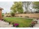 Well-kept backyard offers a green lawn, brick planter beds and flower pots lining the patio at 15140 W Glenrosa Ave, Goodyear, AZ 85395