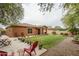 Spacious backyard featuring a manicured lawn, flower pots, and a cozy seating area at 15140 W Glenrosa Ave, Goodyear, AZ 85395
