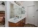 Bathroom boasts double sinks with wood cabinets and a large mirror, adjacent to the bedroom at 15140 W Glenrosa Ave, Goodyear, AZ 85395