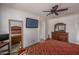 Well-decorated bedroom features a decorative wooden dresser, a mirror, and a wall-mounted TV at 15140 W Glenrosa Ave, Goodyear, AZ 85395
