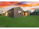 A backyard with a green lawn and the home's exterior visible at dusk at 16600 W Washington St, Goodyear, AZ 85338