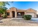 Charming single-story home with desert landscaping, a cozy porch, and an attached two-car garage at 16600 W Washington St, Goodyear, AZ 85338