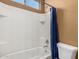 Shower/tub combination with white tiled walls and blue shower curtain at 16600 W Washington St, Goodyear, AZ 85338