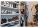 Organized walk-in closet with shelves for shoes, folded clothes, and hanging space for shirts and jackets at 1811 E Tierra Buena Ln, Phoenix, AZ 85022