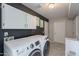 Functional laundry room with modern appliances, overhead storage, and stylish decor at 1811 E Tierra Buena Ln, Phoenix, AZ 85022