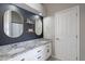 Stylish main bathroom with dual sinks, granite counters, decorative mirrors, and modern fixtures at 1811 E Tierra Buena Ln, Phoenix, AZ 85022