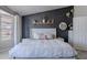Elegant main bedroom with a dark accent wall, cozy bedding, and a view of the backyard through the windows at 1811 E Tierra Buena Ln, Phoenix, AZ 85022