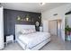 Serene main bedroom featuring a dark accent wall with plants, a plush bed, and access to the closet area at 1811 E Tierra Buena Ln, Phoenix, AZ 85022