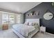 Bright main bedroom with a view of the backyard, a dark accent wall with a decorative shelf, and a cozy atmosphere at 1811 E Tierra Buena Ln, Phoenix, AZ 85022
