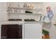 Functional laundry room equipped with modern washer and dryer units, plus shelving for storage at 1946 E Caroline Ln, Tempe, AZ 85284