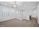 Large open bonus room with stylish light fixture, many windows, and stairway access at 20251 W Hadley St, Buckeye, AZ 85326