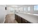 Open bonus room with lots of windows for natural light, hardwood-style floors, and a built-in counter at 20251 W Hadley St, Buckeye, AZ 85326