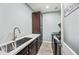 Well-organized laundry room featuring a sink, counter space, and modern appliances at 20251 W Hadley St, Buckeye, AZ 85326