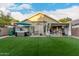 View of home backyard with hot tub, patio dining, and artificial turf at 2038 N Los Alamos St, Mesa, AZ 85213