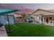 Spacious backyard featuring lush artificial grass, a shed, hot tub, and shaded seating areas at 2038 N Los Alamos St, Mesa, AZ 85213