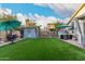 Inviting backyard features lush artificial turf, storage shed, hot tub, and relaxing egg chair with umbrella at 2038 N Los Alamos St, Mesa, AZ 85213
