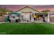 Well-kept backyard featuring a hot tub, outdoor dining, and lush artificial turf at 2038 N Los Alamos St, Mesa, AZ 85213