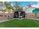Serene backyard featuring lush turf, a shaded gazebo seating area, and charming wall decor at 2038 N Los Alamos St, Mesa, AZ 85213
