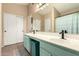 Bathroom featuring double sink vanity with blue cabinets, large mirror, and tiled flooring at 2038 N Los Alamos St, Mesa, AZ 85213