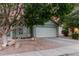 Single-story home featuring a two-car garage and xeriscape landscaping, with mature shade trees at 2038 N Los Alamos St, Mesa, AZ 85213
