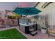 Outdoor hot tub with umbrella and steps, nestled in a cozy backyard patio at 2038 N Los Alamos St, Mesa, AZ 85213