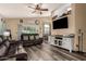 Inviting living room featuring wood-look floors, a ceiling fan, and comfortable leather seating at 2038 N Los Alamos St, Mesa, AZ 85213