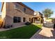 Landscaped backyard featuring artificial grass, a covered hot tub, and brick paver patio at 2116 S Shelby --, Mesa, AZ 85209