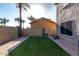 Backyard featuring artificial grass area bordered by a low block wall and brick pavers at 2116 S Shelby --, Mesa, AZ 85209
