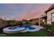 Inviting backyard pool and spa with lounge chairs, lush landscaping, and mountain views at dusk at 2166 N Steele --, Mesa, AZ 85207
