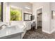 Bright bathroom with a soaking tub, double sinks, and a view to the outdoors at 2166 N Steele --, Mesa, AZ 85207