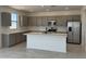 Modern kitchen with gray cabinets, stainless steel appliances, an island, and stylish tile backsplash at 22382 W Monona Ln, Surprise, AZ 85387