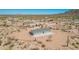 Expansive property in a desert landscape with updated grey house, concrete patio, circle driveway, and fenced yard at 2248 S Nikki Ln, Maricopa, AZ 85139