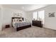 Cozy bedroom with neutral carpet, dresser with decor, and dark wood furniture at 2248 S Nikki Ln, Maricopa, AZ 85139