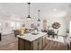 Modern kitchen with island and seating, open to the living and dining areas for seamless living at 2248 S Nikki Ln, Maricopa, AZ 85139