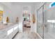 Bathroom featuring double vanity, a glass shower, and a view into the main bedroom at 25338 N 150Th Ln, Surprise, AZ 85387