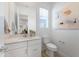 Half-bathroom with modern fixtures, white cabinets, and a decorative painting at 25338 N 150Th Ln, Surprise, AZ 85387