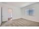 Bright bedroom with neutral carpet, a window with blinds, and a white door to the ensuite at 25338 N 150Th Ln, Surprise, AZ 85387