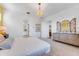 Bright main bedroom with white walls, decorative dresser with mirror, and a modern light fixture at 25338 N 150Th Ln, Surprise, AZ 85387