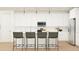 Stylish kitchen showcasing a breakfast bar with seating, modern lighting, and ample cabinet space at 25453 N 176Th Ave, Surprise, AZ 85387