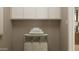 Neutral laundry room with overhead cabinets and a folding table with a hamper at 25453 N 176Th Ave, Surprise, AZ 85387