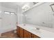 Bathroom featuring double sinks, wood cabinets, framed mirror, and shower-tub combination at 25617 W St James Ave, Buckeye, AZ 85326