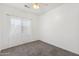 Bright bedroom with neutral carpet, ceiling fan, and a window with white sheer curtains at 25617 W St James Ave, Buckeye, AZ 85326